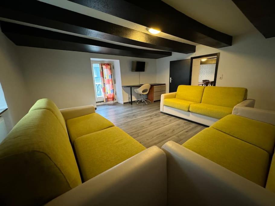 a living room with two yellow couches and a table at Große Monteurwohnung - 7 Personen - KÜCHE WIFI TV in Werdohl