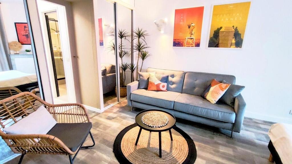 ein Wohnzimmer mit einem Sofa und einem Tisch in der Unterkunft KosyKasa SPA in Cannes