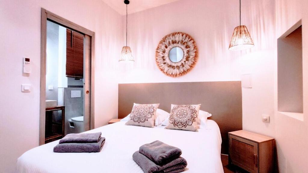 a bedroom with a white bed with two pillows at KosyKasa SPA in Cannes