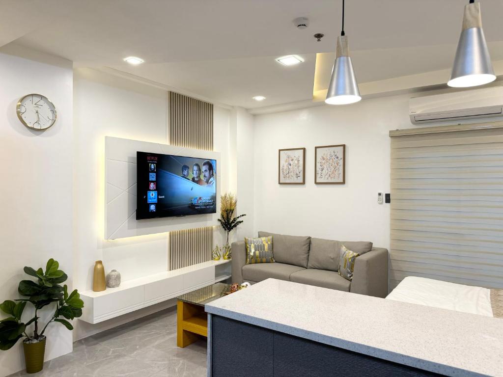 a living room with a couch and a tv on the wall at Luxury Suite near Clark International Airport in Angeles