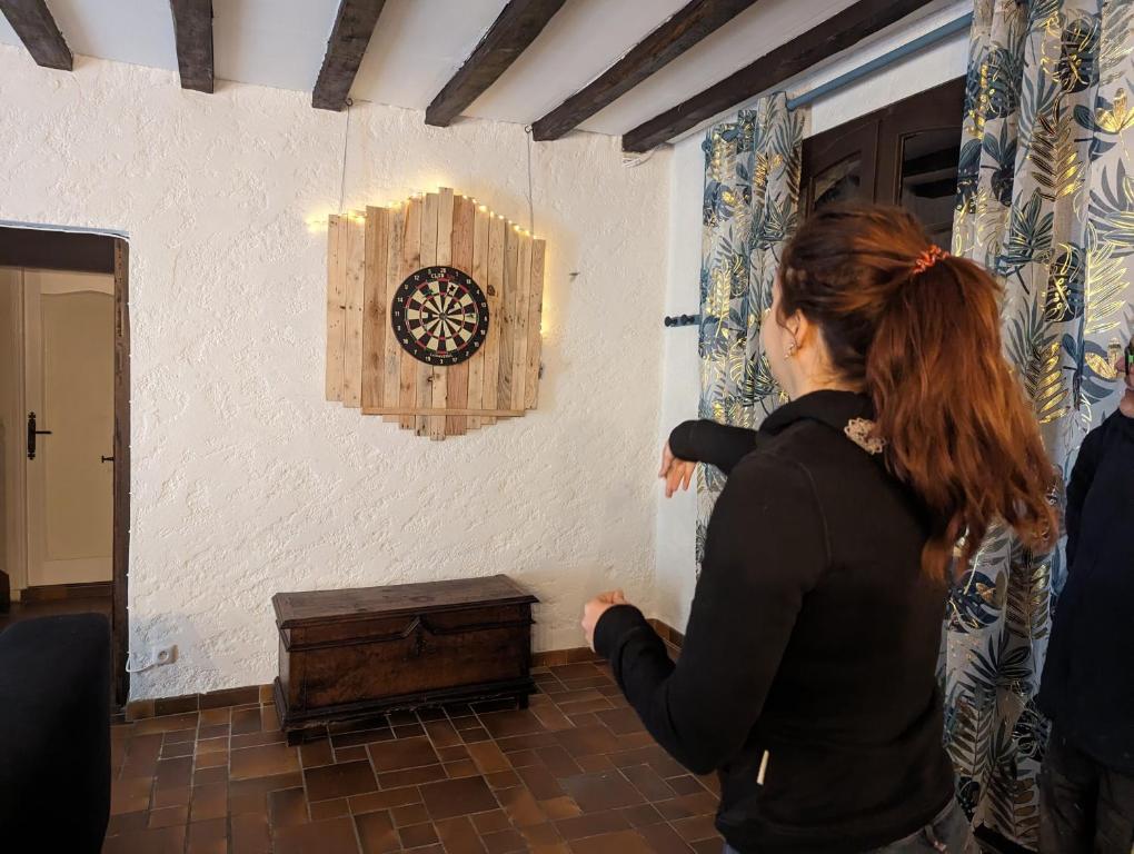 une femme regarde une horloge sur un mur dans l'établissement Sweet Home Dordogne between Sarlat-Souillac, à Peyrillac-et-Millac