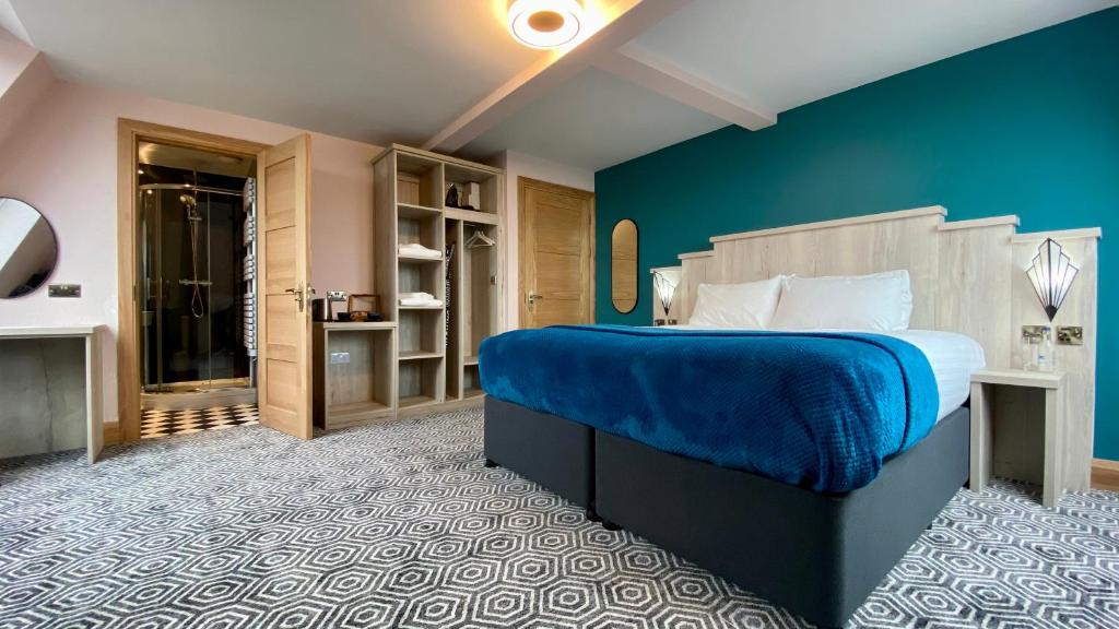 um quarto com uma cama grande e uma parede azul em The Bath Rooms em Morecambe