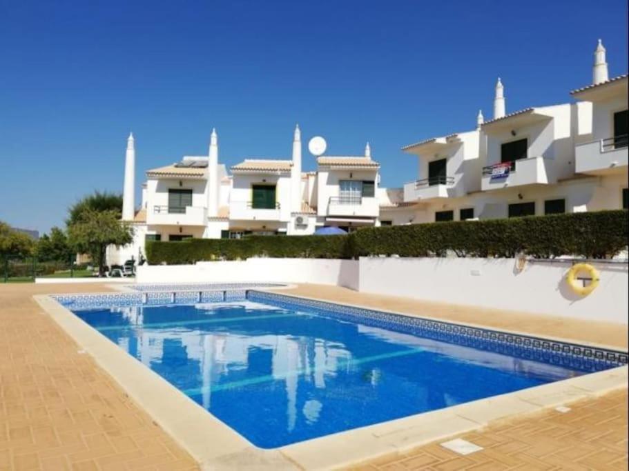 a swimming pool in front of a building at Joia da Galé House - Pool and Garden & BBQ & Galé Beach in Albufeira