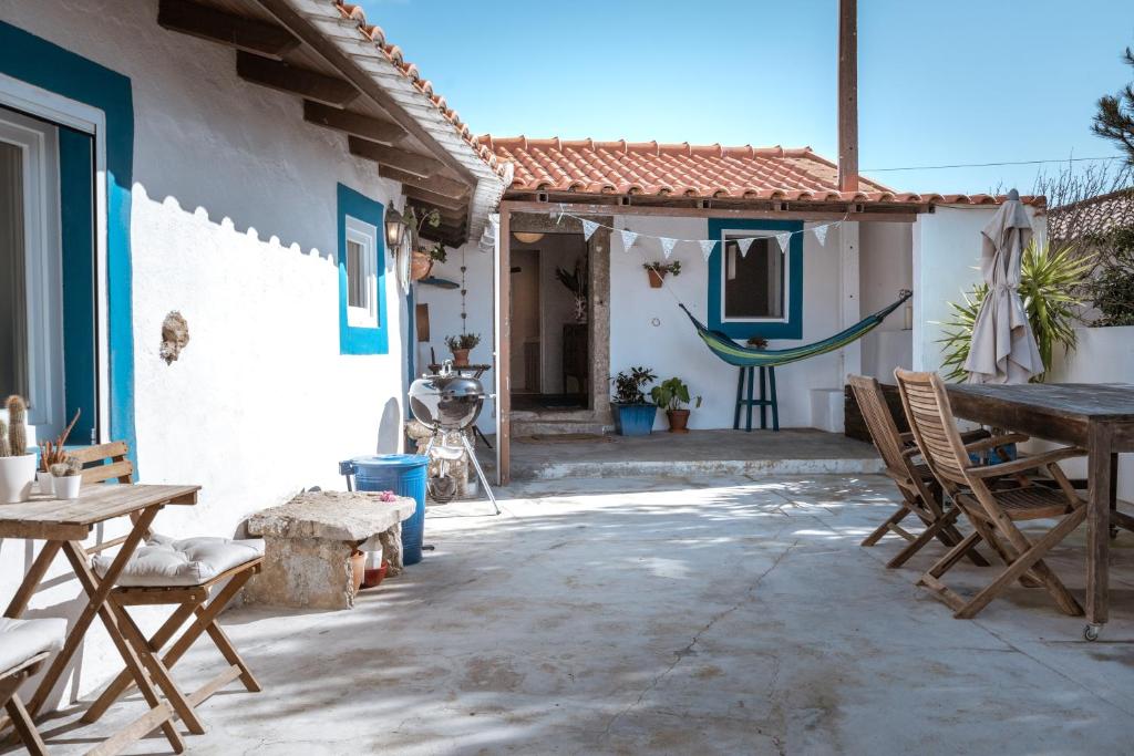 un patio con sillas y una mesa frente a una casa en Refugio d'Alma, en Mafra