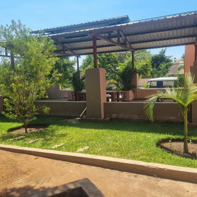 a view of a yard with a pergola at Mukamba Apartment in Livingstone
