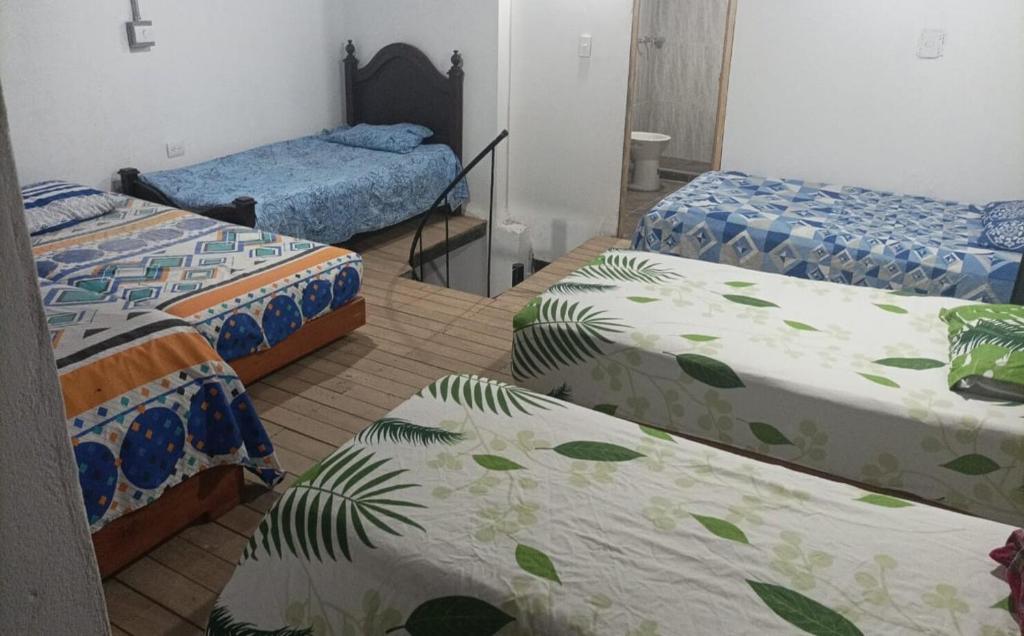 une chambre avec 3 lits avec des feuilles dans l'établissement Apartamento amoblado 302, à San Luis