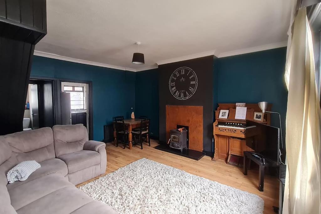 sala de estar con sofá y reloj en la pared en Little house in the City en Dublín