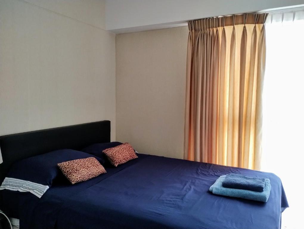 a bedroom with a blue bed with a window at Linda habitación baño privado en casa de familia desayuno incluido in Lima