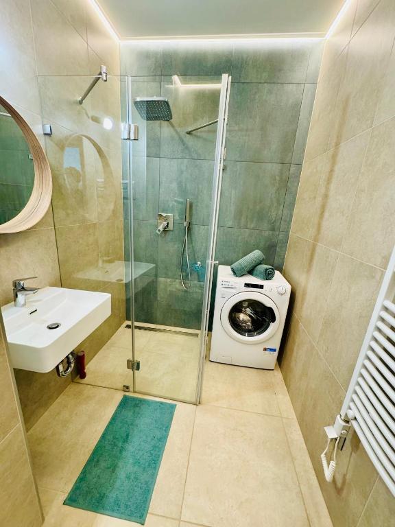 a bathroom with a shower and a washing machine at Fűzliget2- Bamboo in Balatonfůzfő