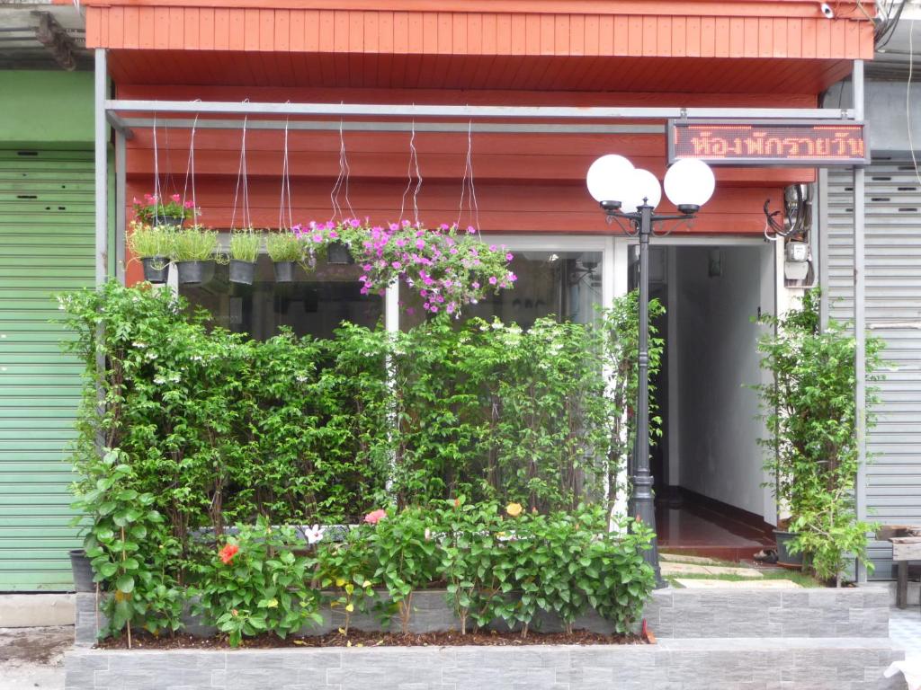 a building with a bunch of plants and flowers at Room For You in Bangkok
