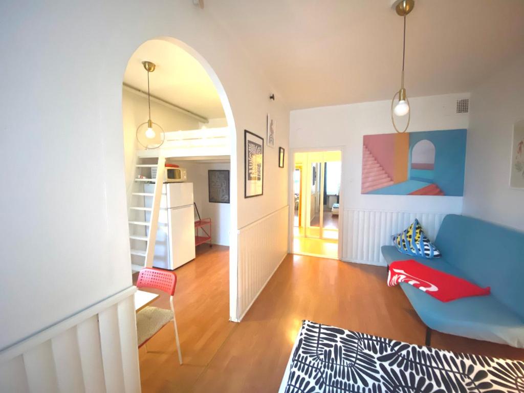 uma sala de estar com um sofá azul e um arco em Small home in Kamppi em Helsinque