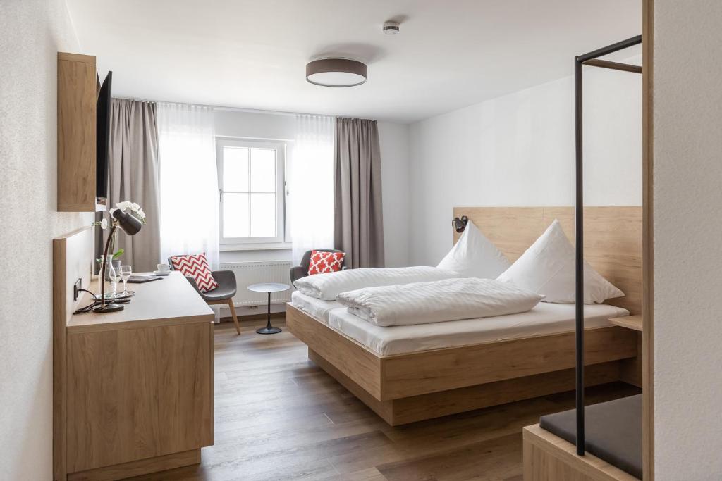 にあるGasthof Zum Roten Hausのベッドとデスクが備わるホテルルームです。