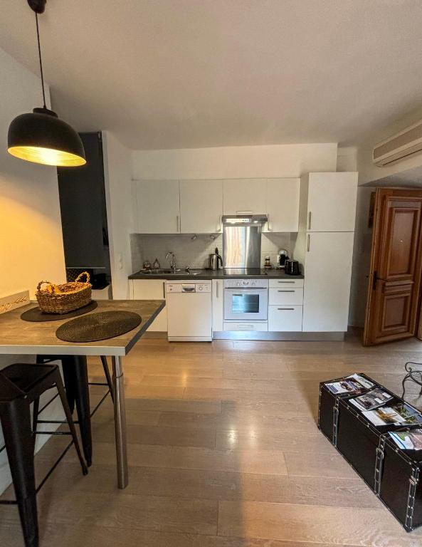 a kitchen with a table and a kitchen with a counter at Appartement Biot Village in Biot
