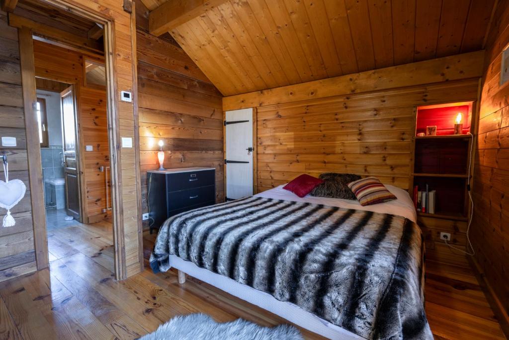 1 dormitorio con 1 cama en una cabaña de madera en Parenthèse Alpine - Barbecue - Terrasse - Parking en Enchastrayes