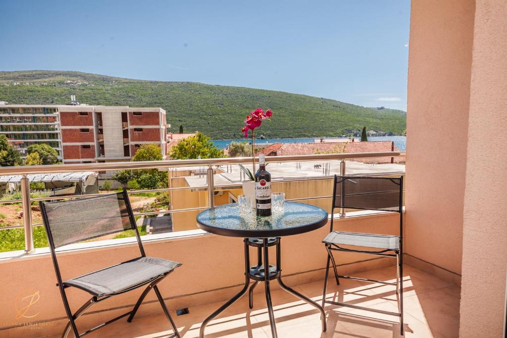 einen Tisch mit einer Flasche Wein auf dem Balkon in der Unterkunft Apartment Rosemary - Happy Rentals in Herceg-Novi