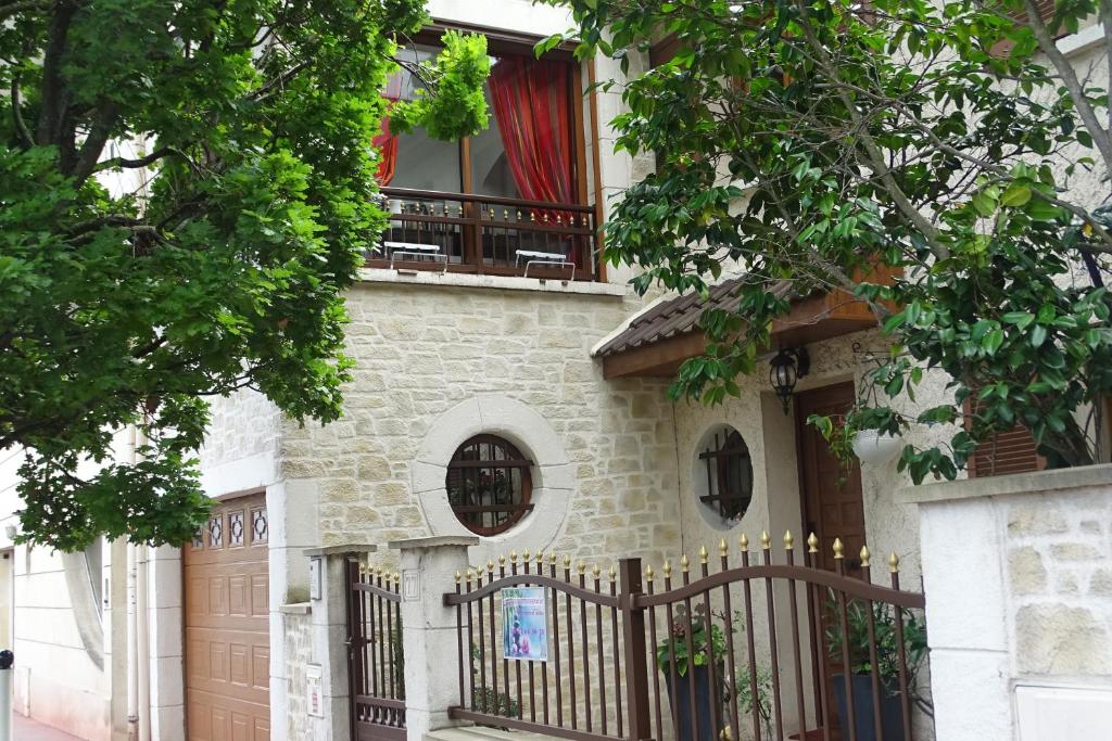 una casa con una valla y una ventana en La bambouseraie, en Montrouge