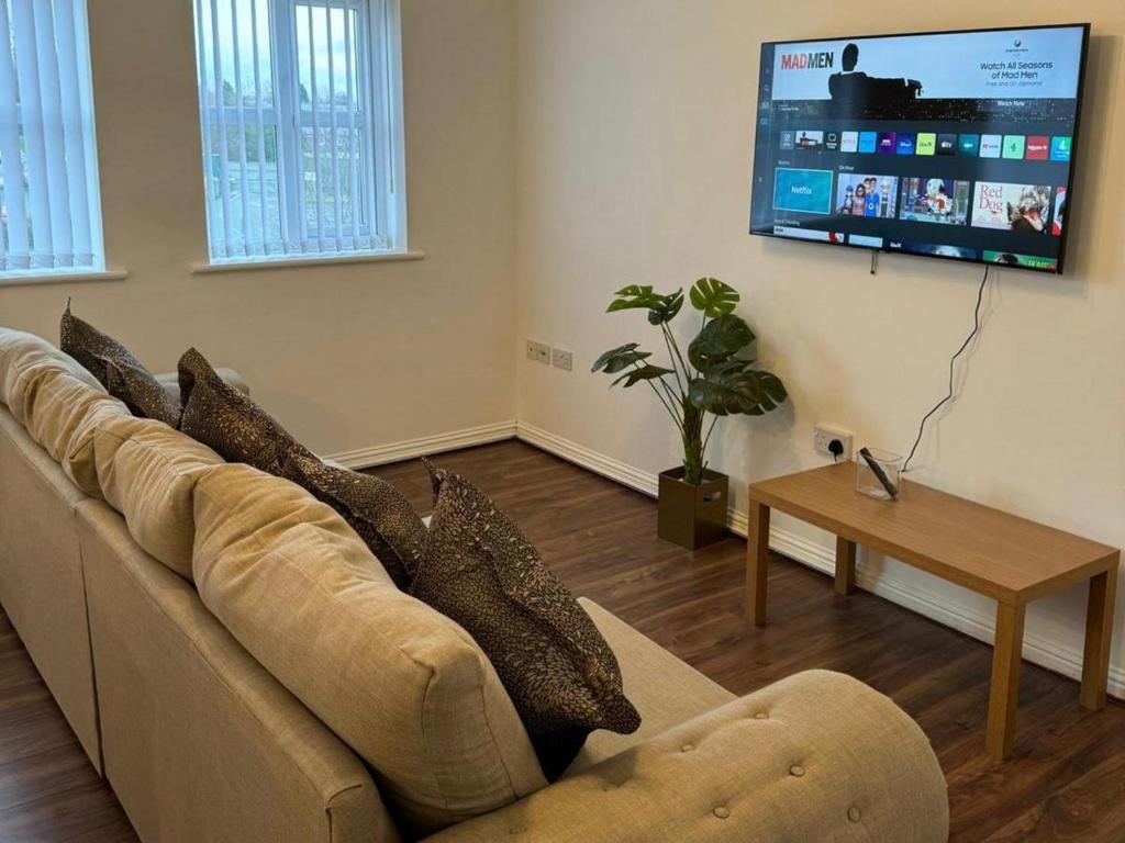 a living room with a couch and a flat screen tv at Manchester flat close to City Centre and Stadium in Manchester