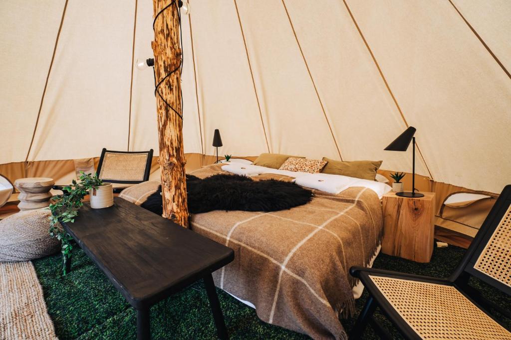 Una habitación con una cama y una mesa en una tienda de campaña en Luxury Boutique Camping, en Selfoss