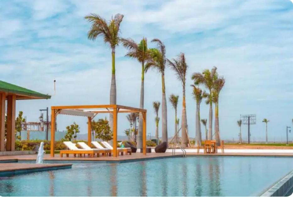uma piscina com palmeiras e um gazebo em Ecusuites Karibao Room 3 Genius playas em Playas