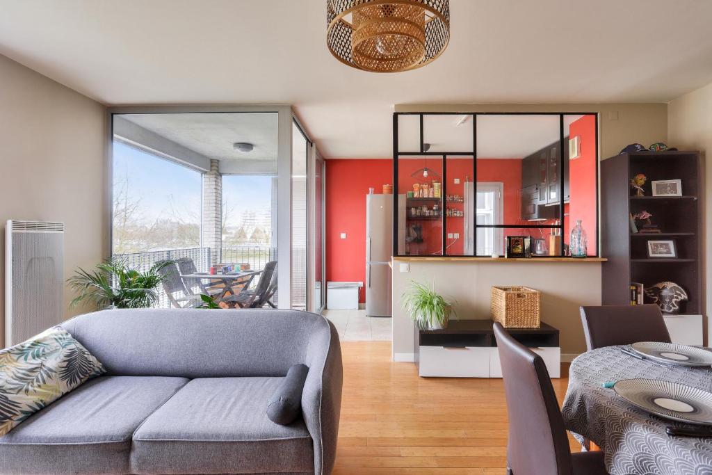 un salon avec un canapé et une table dans l'établissement Séjour sur l'île de Nantes avec vue sur la Loire, à Nantes