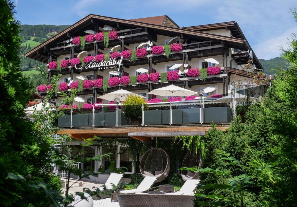 un hôtel avec des chaises et des fleurs devant lui dans l'établissement Boutique Hotel Haidachhof superior, à Fügen