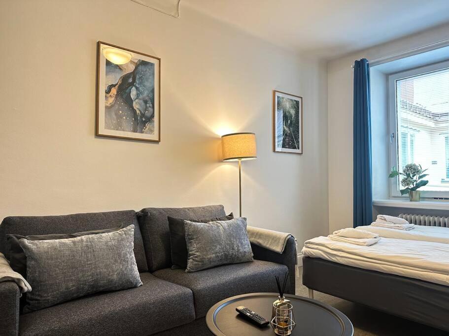 uma sala de estar com um sofá e uma cama em Spacious Studio Apartment em Estocolmo