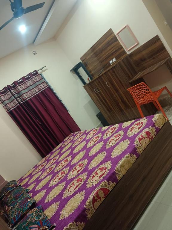 a bedroom with a bed with a purple blanket at Milan Palace Deoghar in Deoghar