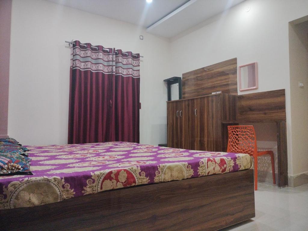 a bedroom with a bed and a chair in it at Milan Palace Deoghar in Deoghar