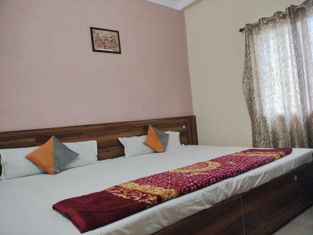 a bedroom with a bed with white sheets and pillows at Milan Palace Deoghar in Deoghar