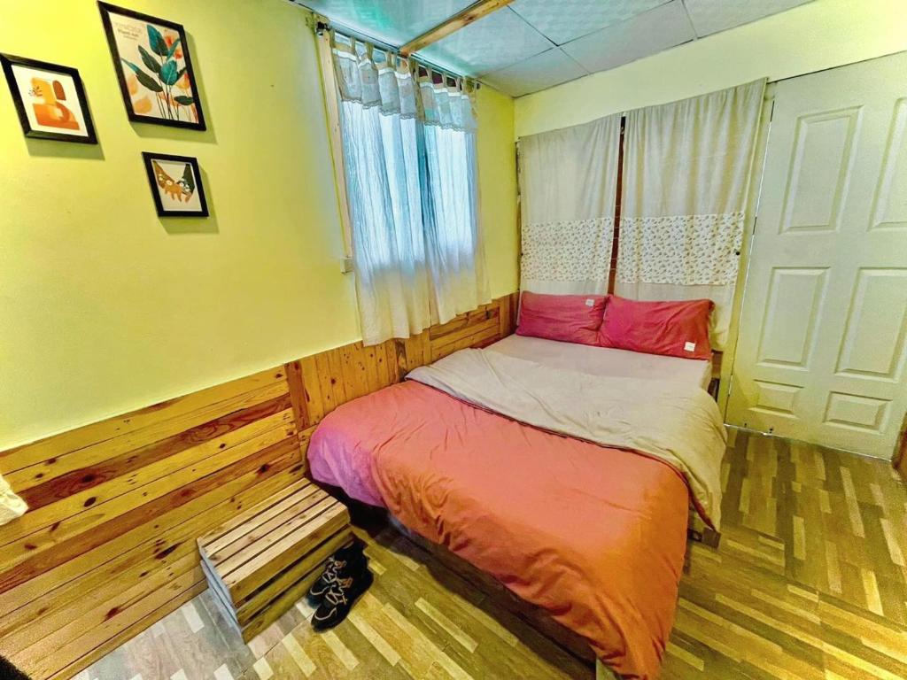uma pequena cama num quarto com uma janela em DALAT INN PEACEFUL em Da Lat