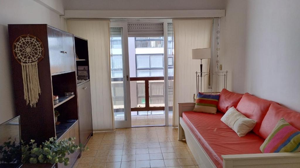 a living room with a red couch in a room at Mar del Plata 2 ambientes en La Perla in Mar del Plata