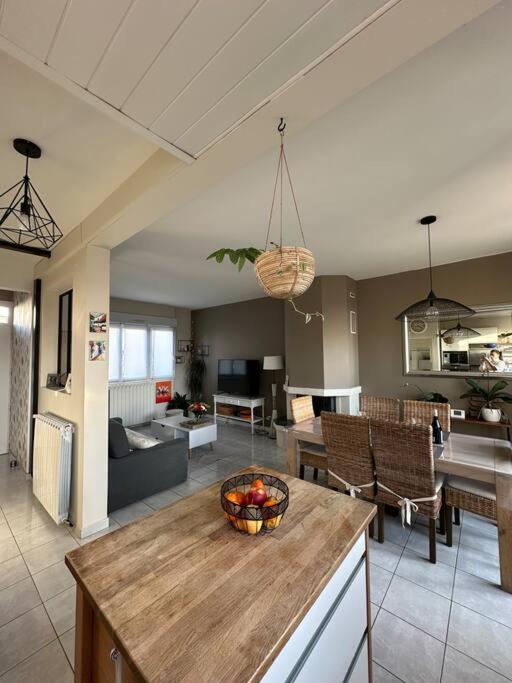 eine Küche und ein Wohnzimmer mit einer Obstschale auf dem Tisch in der Unterkunft La maison du BONHEUR in Sucy-en-Brie