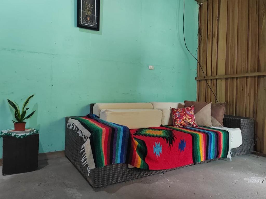 een bank met kleurrijke dekens in een kamer bij Casa los congos in Puntarenas