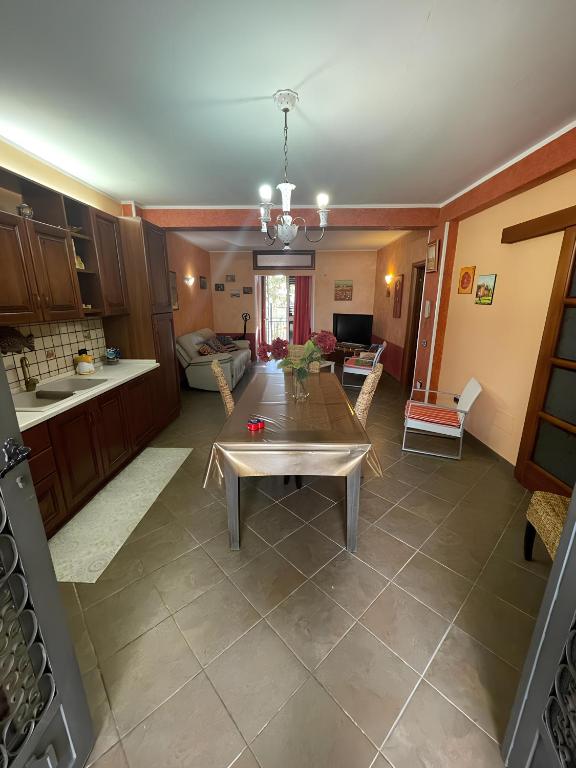 un soggiorno con tavolo e cucina di CasAle a Borgetto