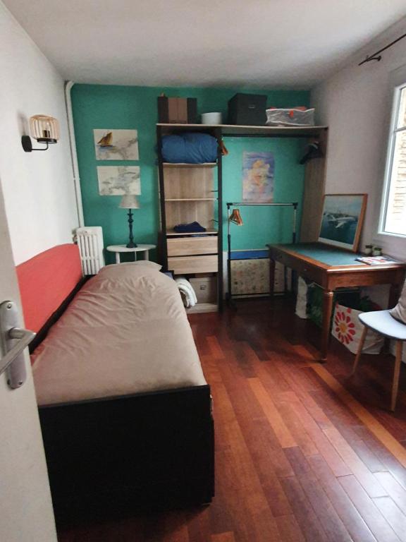 a bedroom with a bed and a desk in it at Chambre privée au calme chez l'habitant in Montrouge
