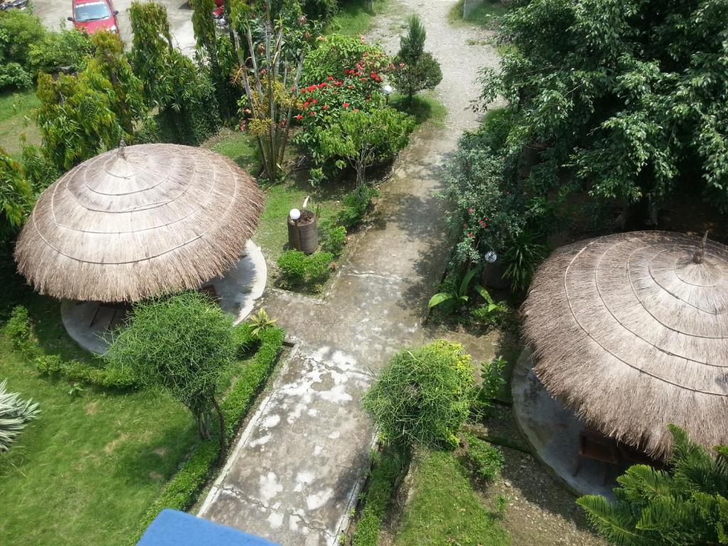 an overhead view of a garden with two large straw umbrellas at Hotel Shiva's Dream in Sauraha
