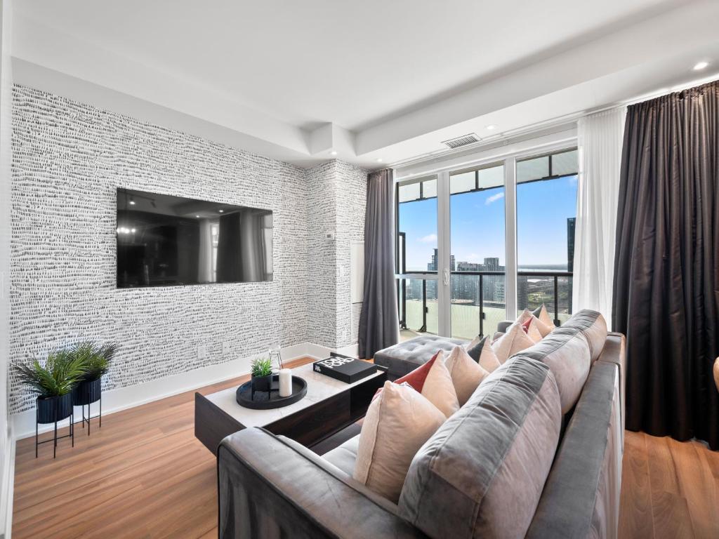 a living room with a couch and a large window at Stylish One Bedroom Suite - Entertainment District Toronto in Toronto