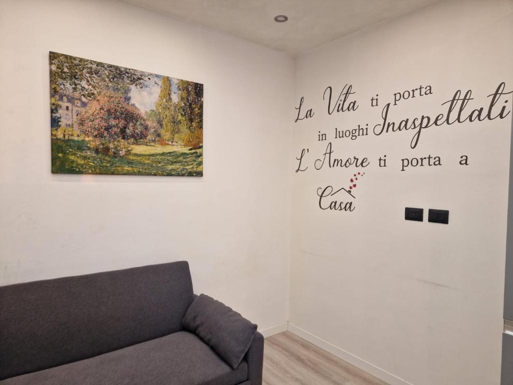 a living room with a couch and a painting on the wall at n&ghomesweethome Monet Elegante appartamento casa vacanze - affari in Milan