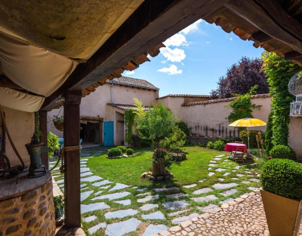 een tuin met een stenen pad en een paraplu bij Casa Rural La Cepedana in Cogorderos