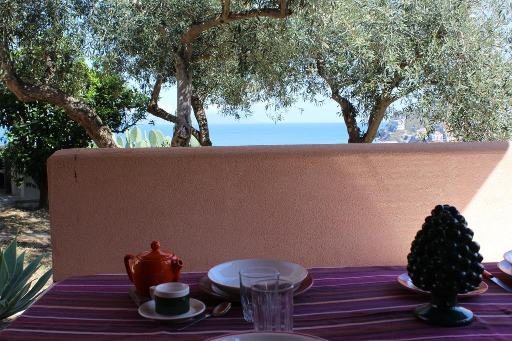 a table with a table cloth with a tea set on it at Gioiosa Marea Appartamento per 4 con vista sulle Eolie Casa Spisidda "Panarea" in Gioiosa Marea