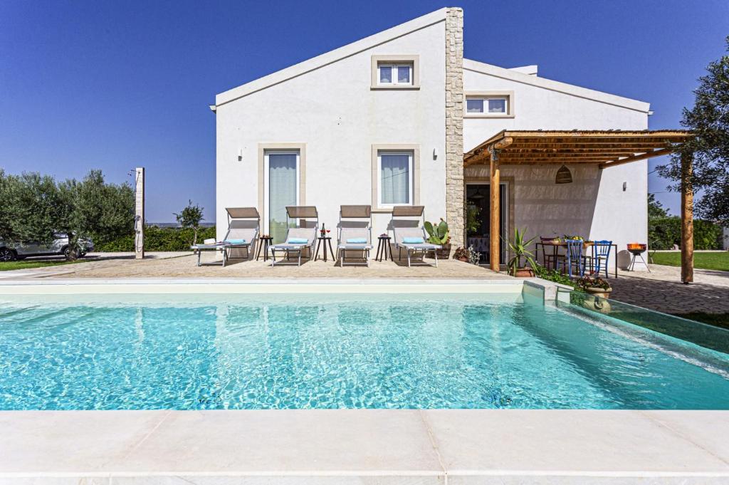 a house with a swimming pool in front of a house at Villa Ginevra by Villa Plus in Ispica