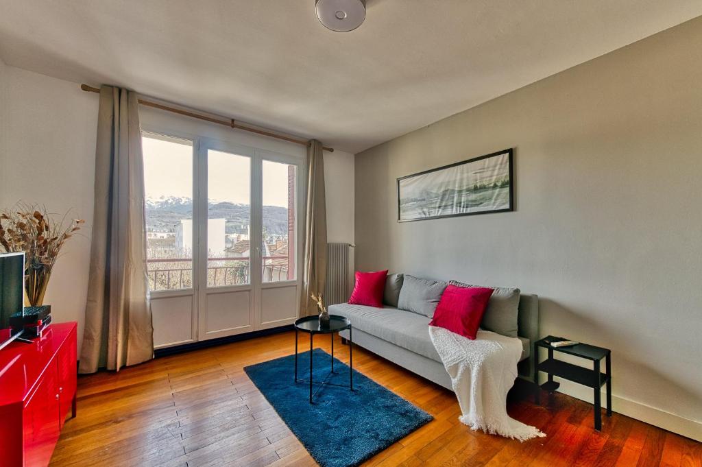 un salon avec un canapé et une grande fenêtre dans l'établissement La Dolce Vita¶ Belle vue ¶ Confort ¶Proche TRAM, à Grenoble