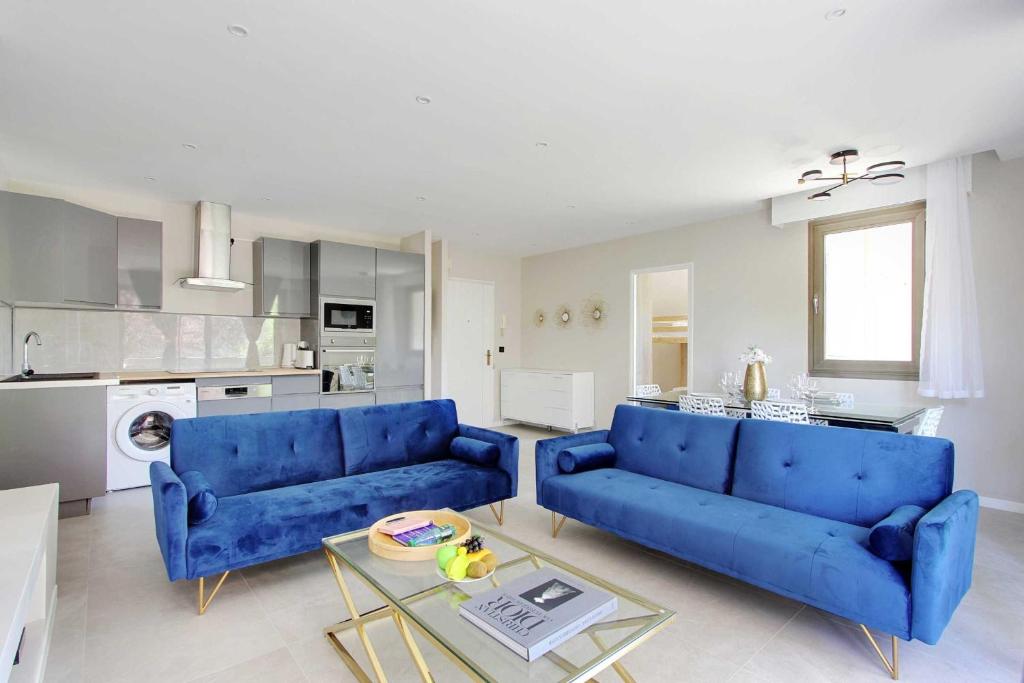 a living room with two blue couches and a kitchen at Super 3BDR avec balcon Pereire in Paris