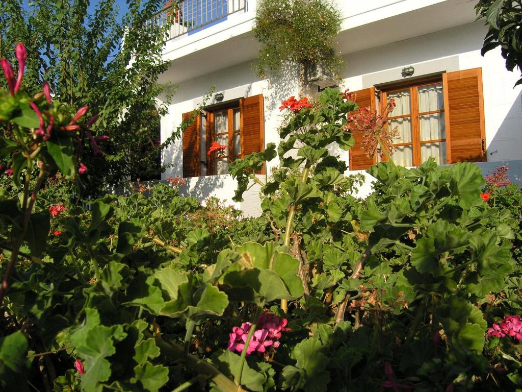 un giardino di fronte a una casa con fiori di Pension Chanioti a Paroikia