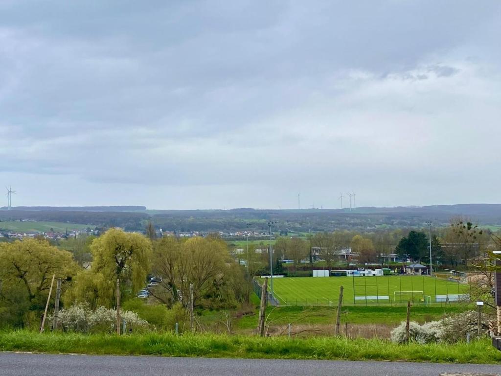 a tennis court on a hill with a field at Cosy Room in Remich in Remich