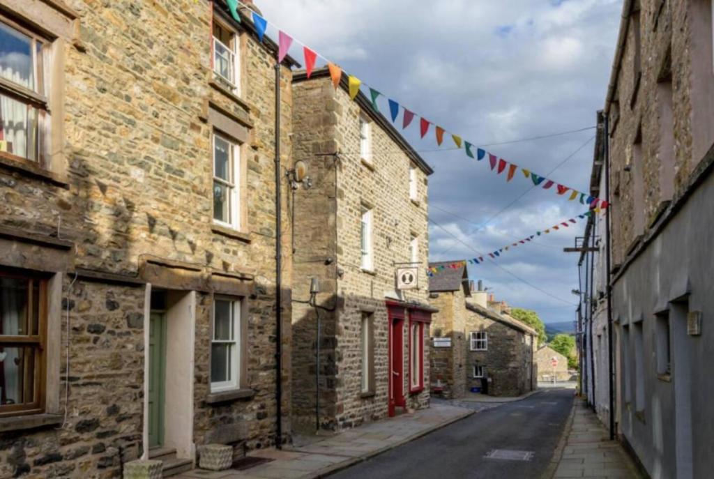 an alley with flags and buildings in an old town at The Penthouse - in the heart of Sedbergh in Sedbergh