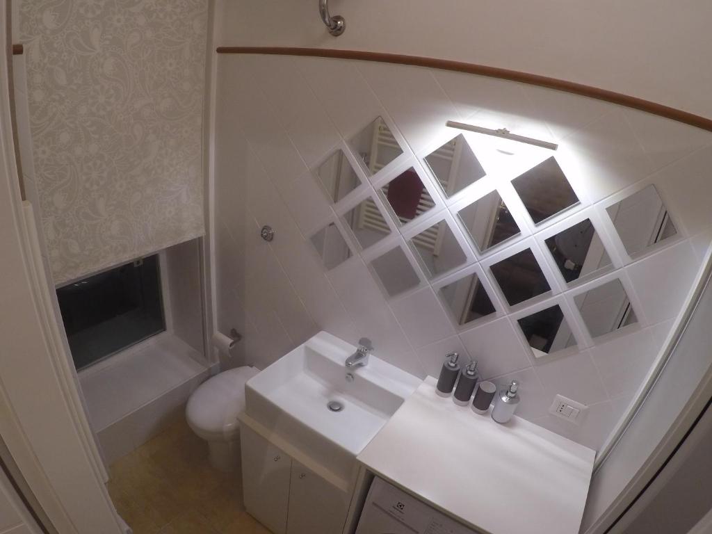 uma casa de banho com um lavatório, um WC e um espelho. em Garibaldi Guest House em Macerata