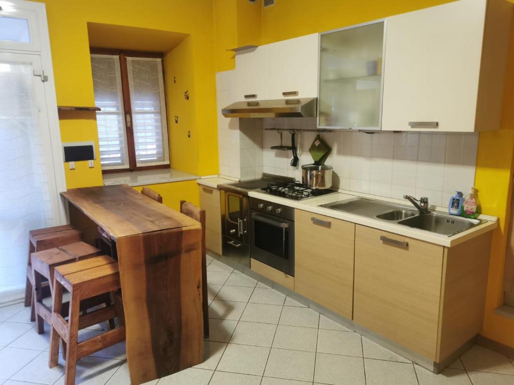 a kitchen with yellow walls and a stove and a sink at Casa Viarago in Pergine Valsugana