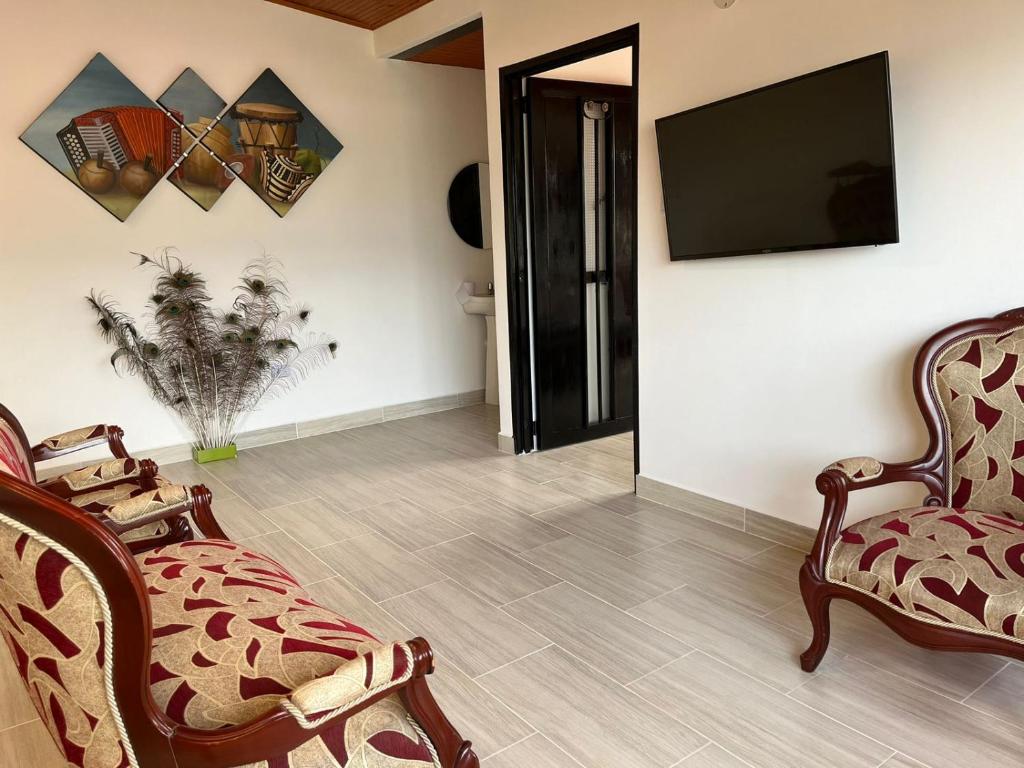 a living room with two chairs and a flat screen tv at Hermoso apartamento Duplex in Guaduas