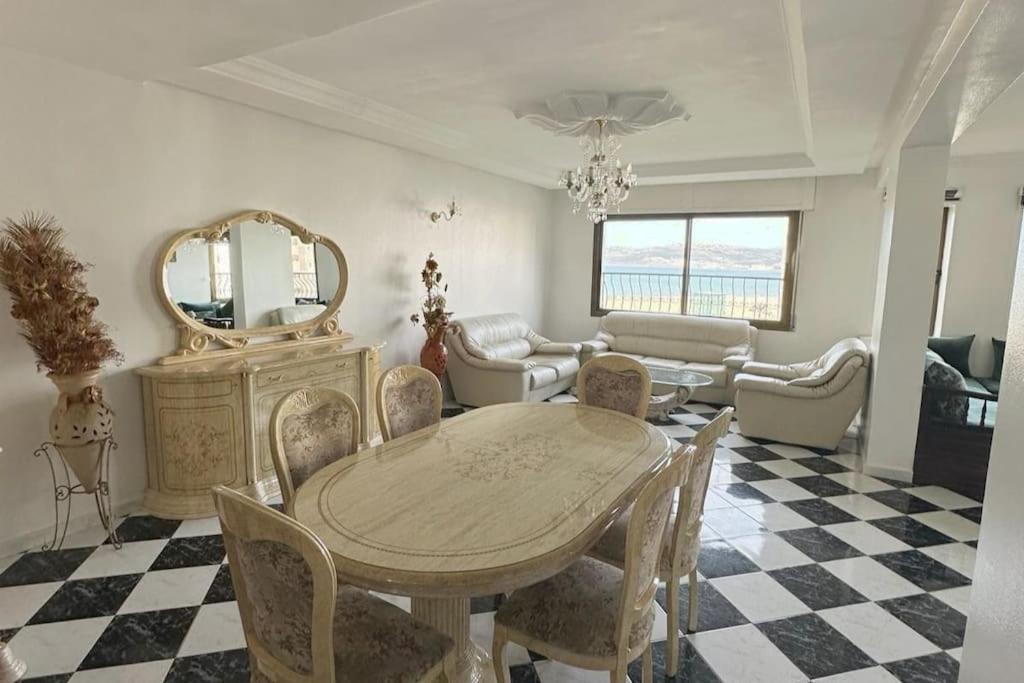 jadalnia ze stołem, krzesłami i lustrem w obiekcie Beautiful Sea View Apartment in Tangier w mieście Tanger